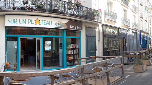 Sur un plateau est un bar à jeux dans lequel petits et grands joue à des jeux de sociétés modernes autour d'une boisson et d'un casse-croûte.