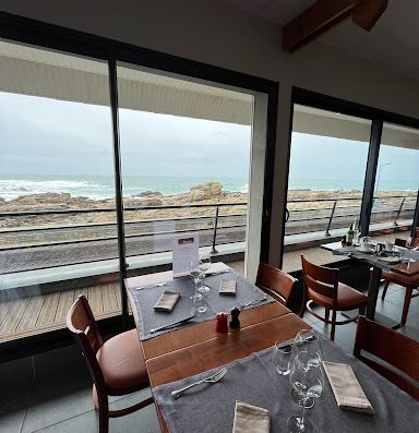 le Restaurant Les Rochers vous accueille dans un cadre moderne et raffiné avec ses grandes baies vitrées donnant sur la mer